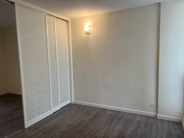 an empty room with a closet and a light on the wall